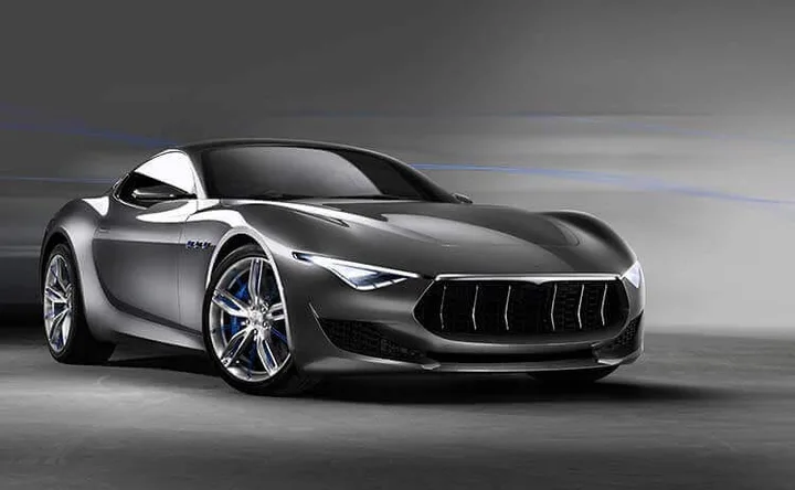 Grey grand coupe shown from the front three-quarter view on a road-like studio background